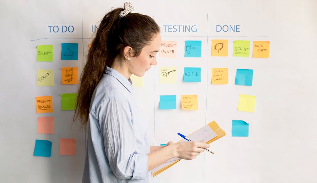 Virtual Assistant standing in front of post it lists with tasks