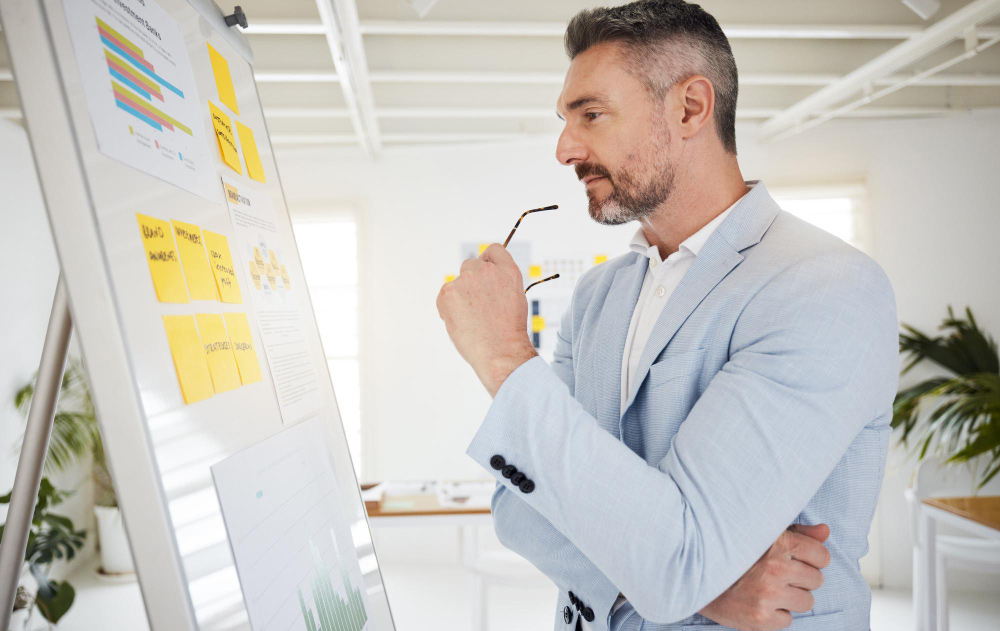 A focused chief executive analyzing strategic plans in a quiet, modern office, representing the deep work made possible by effective delegation to an executive assistant.