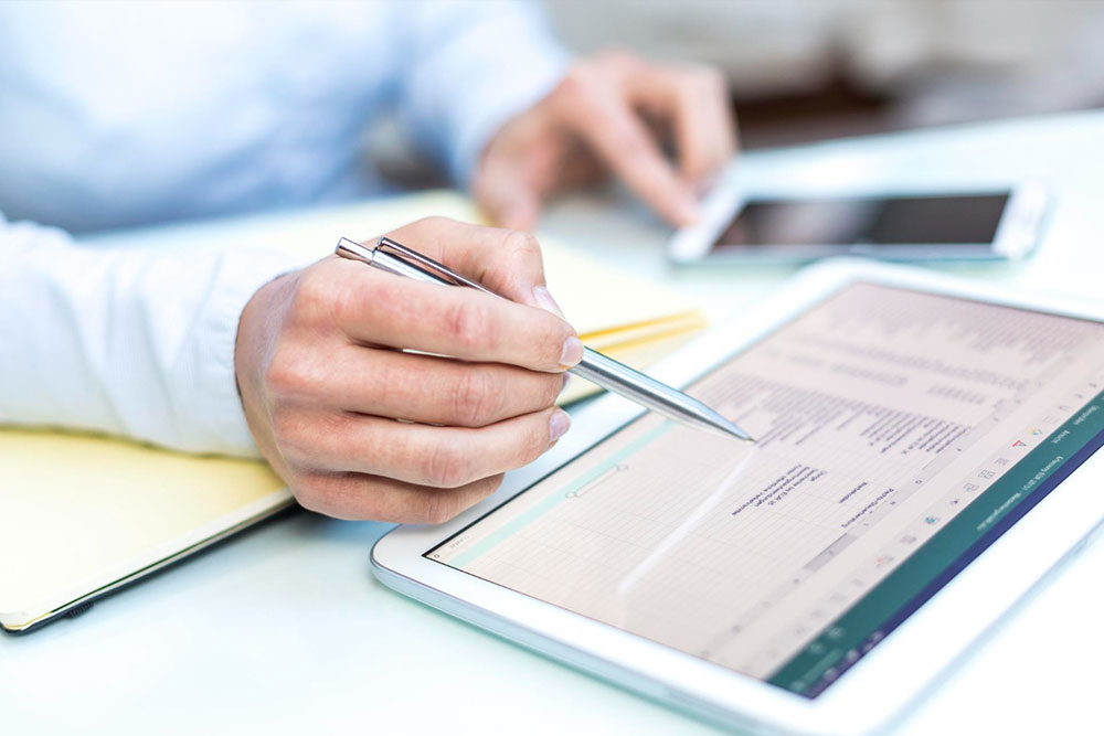 A business professional writing a prioritized task list in a notebook, categorizing recurring administrative work, energy-draining tasks, and strategic projects.