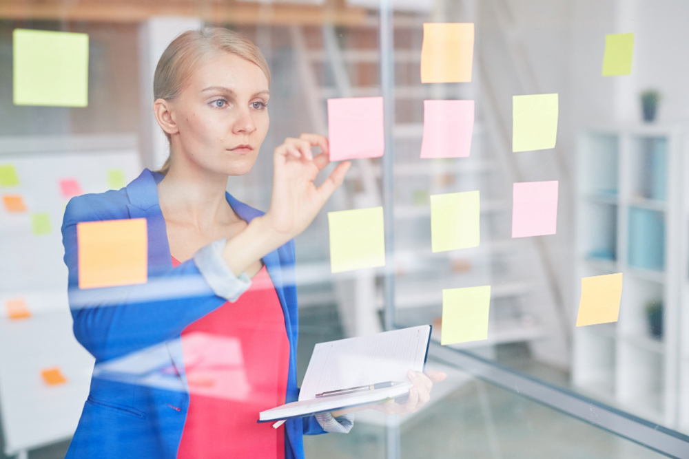 A business executive reviewing a strategic checklist and roadmap in a notebook to decide on the best executive assistant investment model.