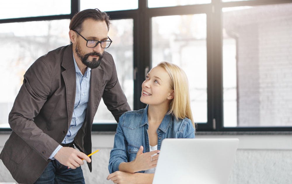 A dedicated executive assistant reviewing strategic documents with a CEO in a high-end corporate office, representing the deep integration of in-house support.