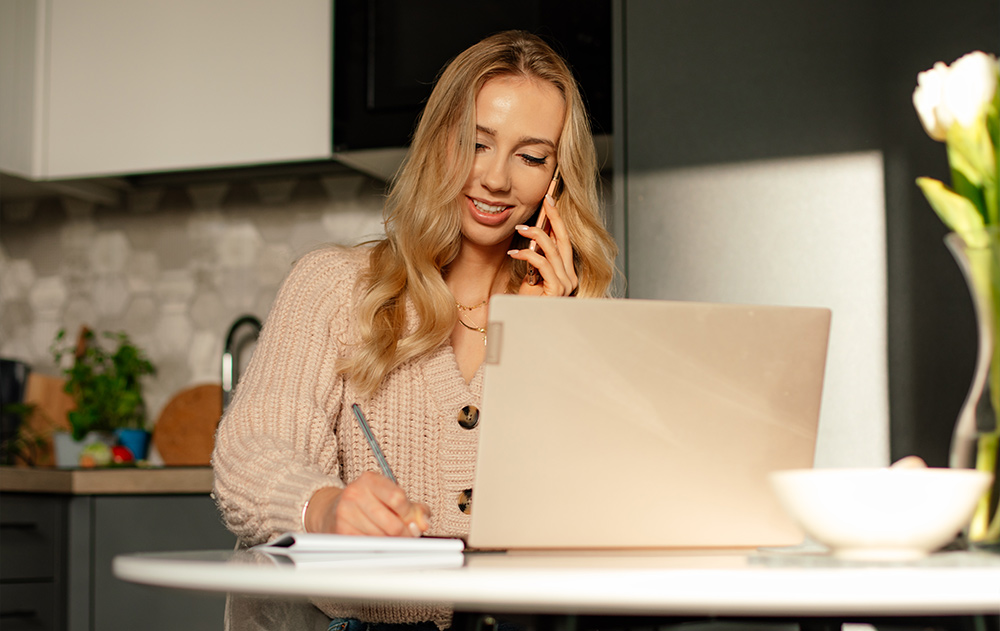 A remote virtual assistant working on a laptop in a home office, managing a digital checklist and email inbox for a client.